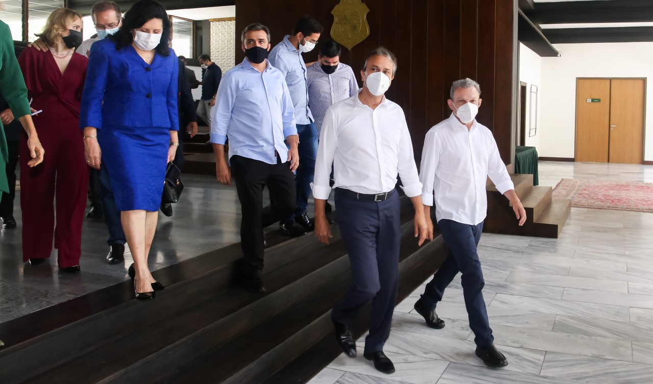 governador, prefeito e um grupo de pessoas caminham no hall do palácio da abolição